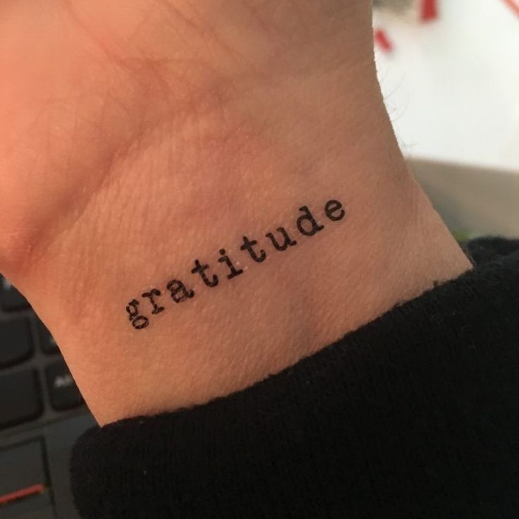 a tattoo that reads gratitude on the wrist