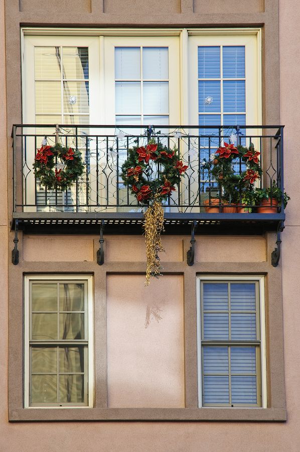 a balcony with potted plants on the balconies and flowers hanging from it