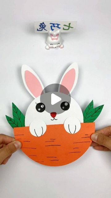 someone is holding up a cut out of a rabbit in a carrot