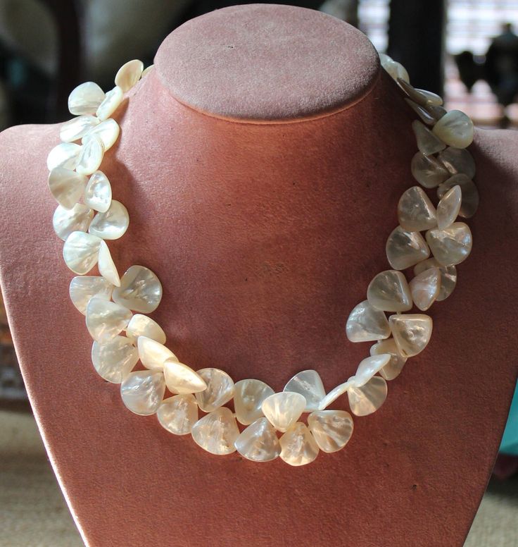 Listed above is a magnificent necklace of lustrous mother of pearl petals forming an exquisite floral pearl necklace. Strung and knotted on silk, this necklace ends with a substantive sterling silver hook and eye clasp...so easy to put on and take off. This beautiful necklace was created with some of the best quality mother of pearl I've ever seen. Each beautifully formed petal possesses lustrous depth, shine and dimension, creating a circle of light enhancing any complexion. It measures 17 inch Luxury Artisan Mother Of Pearl Necklaces, Luxury Pearl Drop Necklace In Mother Of Pearl, Luxury Bohemian Mother Of Pearl Necklace, Luxury Artisan Necklace With Mother Of Pearl, Luxury Mother Of Pearl Necklace Fine Jewelry, Luxury Unique Mother Of Pearl Necklaces, Elegant Shell-shaped Pearl Drop Necklace, Elegant Flower-shaped Mother Of Pearl Jewelry, Elegant Mother Of Pearl Flower Jewelry