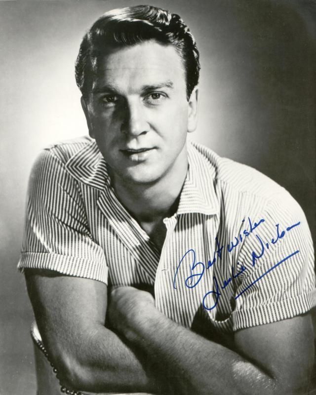 a black and white photo of a man with his arms crossed