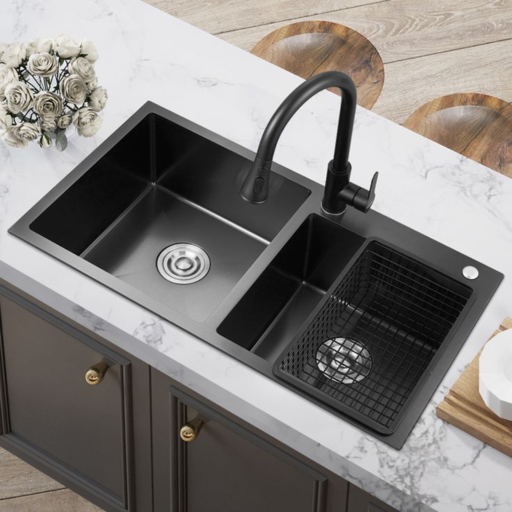 a kitchen sink with two black faucets on the counter