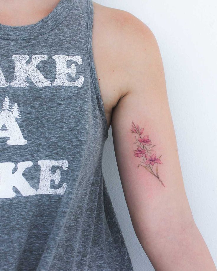 a woman with a tattoo on her arm that says make a lake and has flowers in it