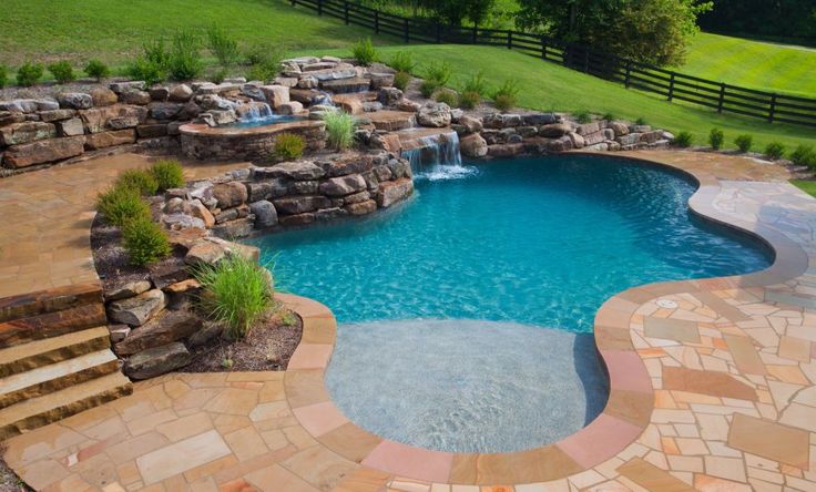 an outdoor swimming pool surrounded by stone steps