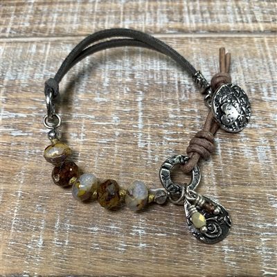 a brown leather bracelet with charms and beads