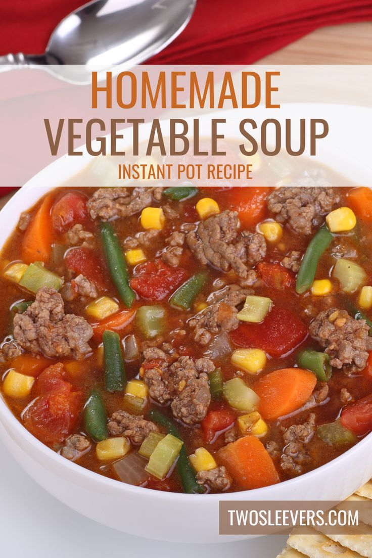 a white bowl filled with vegetable soup next to crackers and a red napkin on the side