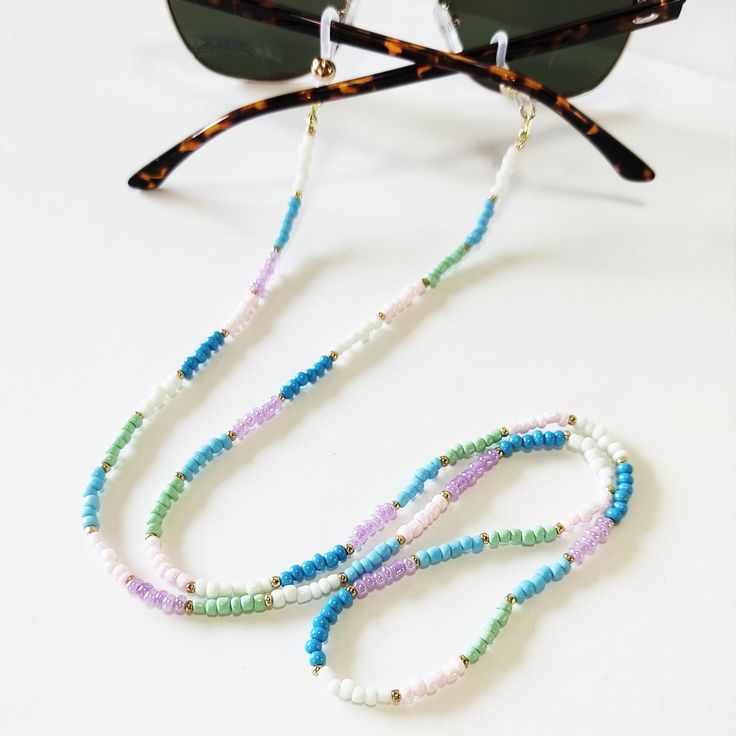 Pastel beaded sunglasses holder, Multicolor beaded sunglasses cord, Sunglasses necklace, Colorful glasses holder, Sunglasses strap Beautiful fashion trend sunglasses beaded string This sunglass strap is lightweight, comfortable to wear and secures your sunglasses on your neck. Fashion trend accessory for the summer! Total length is 70cm / 27.7 inches. Beautifully packaged and ready for gift giving. JEWELRY CARE: Please take care of your jewelry do not wear in the shower, swimming pool, or to bed Trendy White Glasses Chains With Colorful Beads, Trendy White Glasses Chains For Festival, Bohemian Multicolor Glasses Chains For Summer, Multicolor Bohemian Glasses Chains For Summer, Multicolor Glasses Chains For Summer Beach, Handmade White Glasses Chains For Summer, White Glass Glasses Chains With Colorful Beads, Adjustable Multicolor Glasses Chains For Festivals, White Adjustable Glasses Chains For Summer