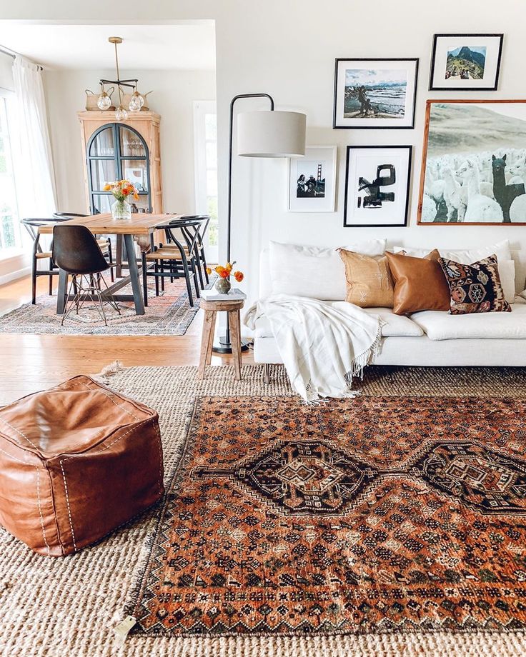 a living room filled with lots of furniture and pictures on the wall above it's couch