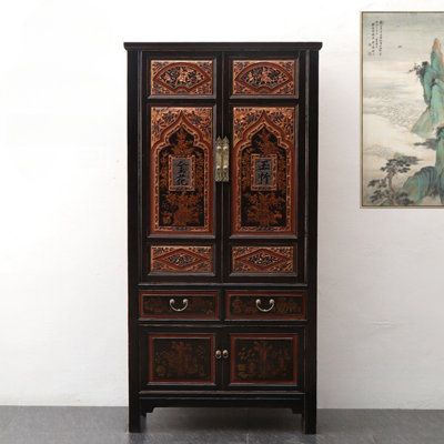 an ornate wooden cabinet next to a painting on the wall in a room with white walls