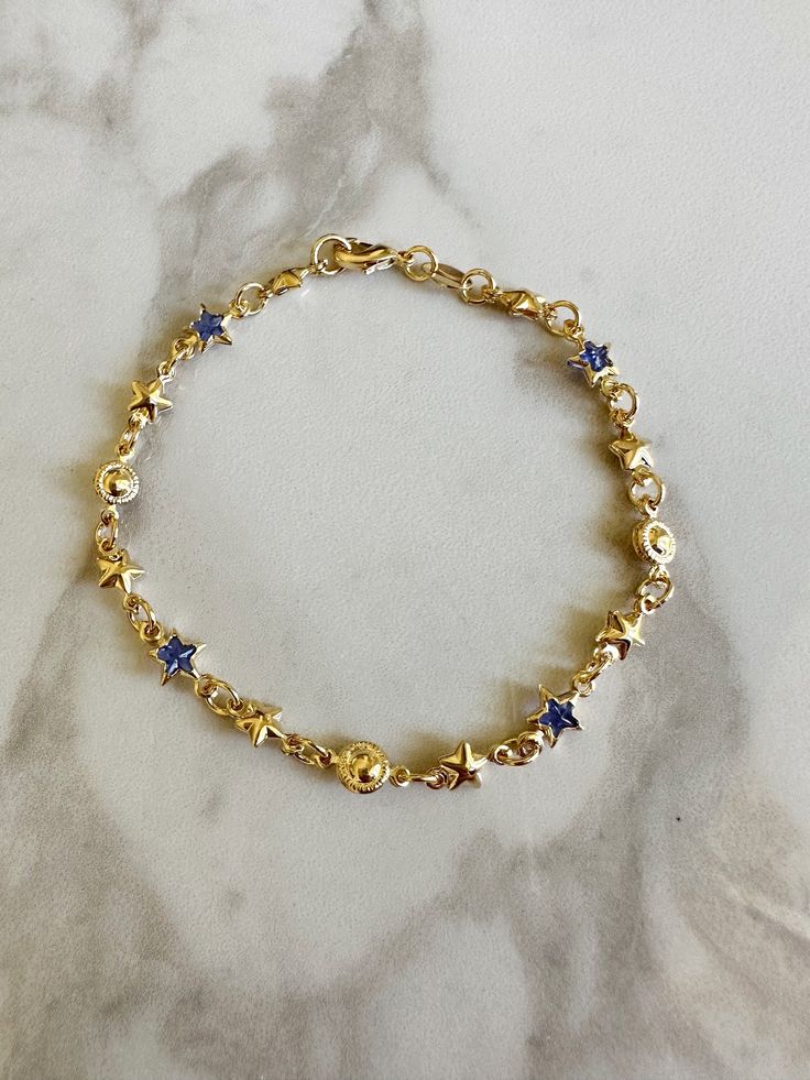 "Perfect worn on its own or layered with our other bracelets. 18k gold filled. Cubic zirconia 7\" length Ready to ship *18k gold filled is a more affordable alternative to solid gold jewelry. Gold filled is a layer of gold bonded onto a base metal with heat and pressure that contains 100+ times more gold than gold plated jewelry.  *It is very durable and tarnish resistant.  *With proper care, gold filled jewelry can last several years. Avoid contact with harsh chemicals, perfumes, water, etc.  *Gold filled jewelry can be worn by people with sensitive skin because it is hypoallergenic, lead free and nickel free." Blue And Gold Bracelets, How To Layer Bracelets, Gold And Blue Aesthetic, Gold And Blue Jewelry, Blue And Gold Jewelry, Blue Gold Jewelry, Vintage Gold Jewellery, Gold Star Jewelry, Bracelets Layering