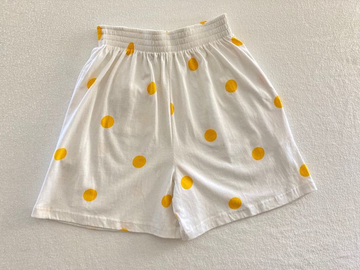 Vintage 1990's white summery elastic waist wide leg shorts with large yellow polka dots and yellow bow on back pocket by Betty Blue Made in Portugal 100% Cotton Good vintage condition with no rips or stains Tag shows Medium Measurements (laying flat): Waist: 13" - 16" Rise: 15" Length: 18 1/4" Inseam: 5 1/4" Our items are vintage, older and/or pre-loved and may show signs of age. Items may have some imperfections, including small holes, marks or stains. We do our best to note all flaws and pictu Casual Polka Dot Bottoms For Summer, Casual Polka Dot Summer Bottoms, Polka Dot Bottoms For Vacation In Spring, White Retro Bottoms For Summer, Retro White Bottoms For Summer, Retro White Summer Bottoms, White Retro Summer Bottoms, Retro Summer Shorts With Elastic Waistband, Casual Polka Dot Shorts For Summer