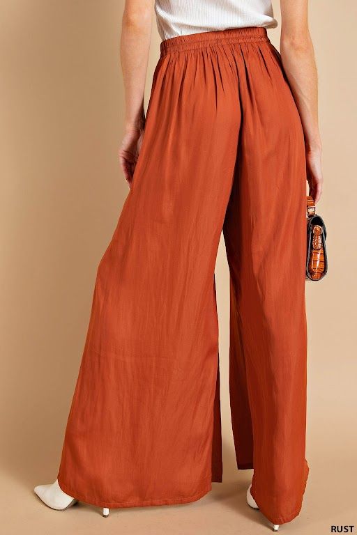 Description Add a touch of elegance (and comfort) to your wardrobe with our Blushing Satin Pants. Featuring a light weight, flowy fit and an elastic waistband, these pants are perfect for any occasion. And with convenient side pockets, you'll never have to leave anything behind. Rust never looked so good!" Specs Self: 100% Polyester Unlined Hand wash cold Do Not Bleach Hang dry Fits true to size - model is wearing a small S (0-4), M (6-8), L (10-12) SKU#: IS-003360 Please note that all online inventory reflects inventory in store. Chic Summer Pull-on Style Pants, Trendy Full Length Pants For Vacation, Trendy Full-length Pants For Vacation, Trendy Pants For Vacation, Full Length Rayon Pants For Loungewear, Wide-leg Rayon Harem Pants For Loungewear, Rayon Wide-leg Harem Pants For Loungewear, Chic Wide Leg Bottoms With Comfort Waistband, Loungewear Bottoms With Elastic Waistband In Rayon