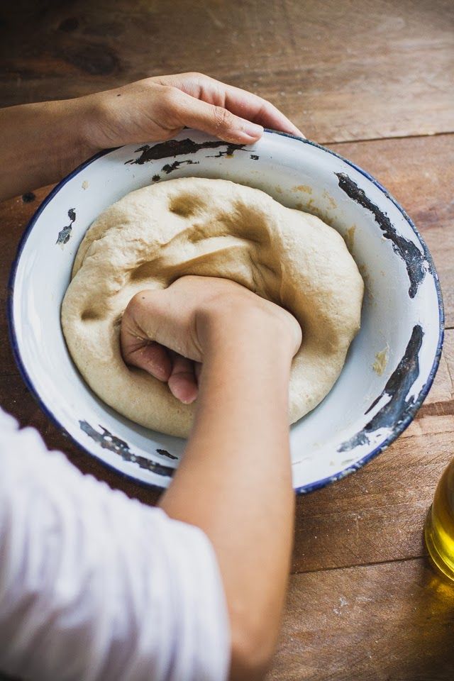 a person is kneading bread into a bowl