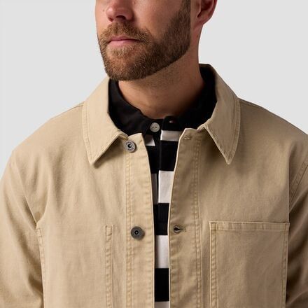 When it's too hot for a puffy and too cold for a tee, we throw on our Stoic Workwear Chore Coat. The buttoned closure and vintage vibe keep our casual 'fit slightly elevated, while the plethora of pockets frees up our hands. Casual Beige Tops With Snap Buttons, Fall Streetwear Tops With Buttoned Pockets, Casual Beige Tops For Outdoor, Casual Outdoor Outerwear With Buttoned Pockets, Casual Unstructured Outerwear With Snap Buttons, Casual Khaki Tops With Buttoned Pockets, Casual Outerwear With Snap Buttons, Vintage Winter Tops For Everyday, Casual Relaxed Fit Khaki Outerwear