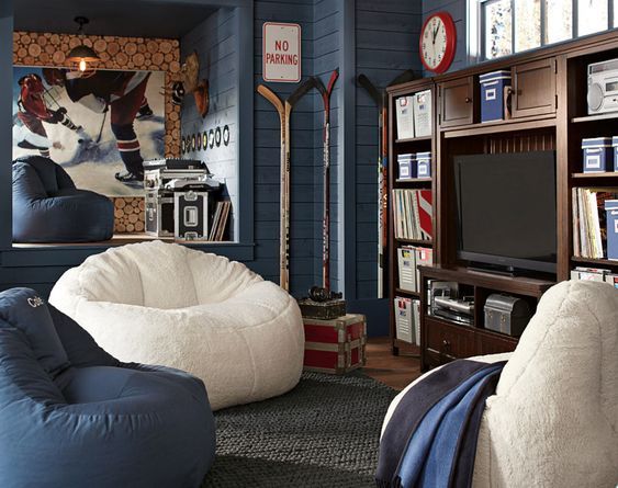 a living room filled with furniture and a flat screen tv mounted on a wall next to a bookshelf