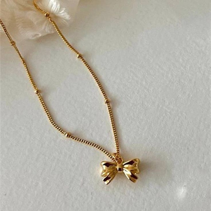 Tie your outfit together with our Bowknot Charm Necklace. This playful accessory features a charming bowknot design in both silver and gold, adding a touch of whimsy to your look. Bring some fun to your style and make a statement with this unique necklace. Gold Necklace With Ribbon For Gift, Gold Necklace With Ribbon Perfect For Gifts, Gold Butterfly Knot Necklace For Gift, Gold Necklaces With Butterfly Knot For Gift, Gold Necklace With Butterfly Knot For Gift, Gold Necklace With Decorative Bow For Party, Adjustable Necklace With Decorative Bow As Gift, Adjustable Necklace With Decorative Bow For Gifts, Gold Necklaces With Bow As Gifts