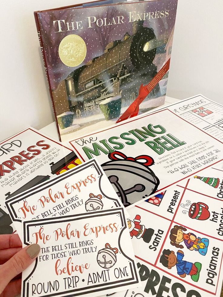 a hand holding a mouse next to a book about the polar express and other activities