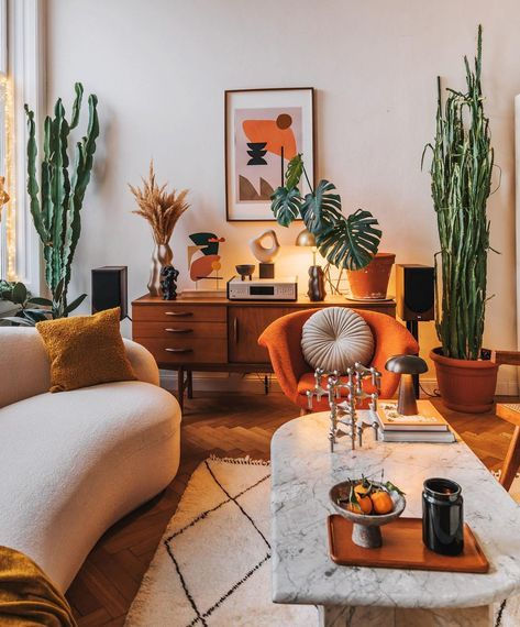 a living room filled with lots of furniture and potted plants on top of it