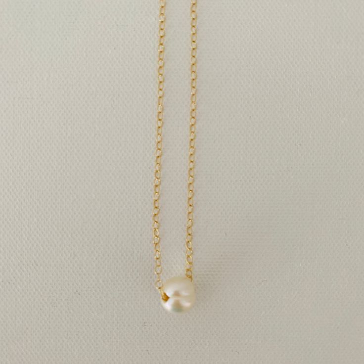 Just A Pearl! This simple yet elegant necklace is part of my Just A Pearl collection. One single pearl dangles from a delicate gold necklace. It measures 16 inches and length and can be adjusted to 15 inches for choker length. Classic Gold Charm Necklace With Pearl Drop, Minimalist Gold Charm Necklace With Pearl, Minimalist Pearl Charm Necklace With Round Pendant, Minimalist Pearl Chain Necklace With Pearl Charm, Minimalist Pearl Drop Necklace With Pearl Chain, Classic Gold Pearl Chain Charm Necklaces, Classic Gold Charm Necklace With Pearl Chain, Gold Minimalist Charm Necklace With Pearl Chain, Gold Minimalist Charm Necklaces With Pearl Chain