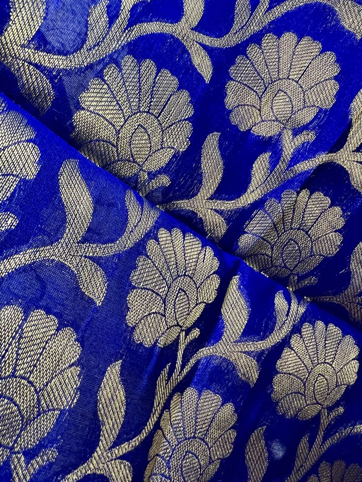 Beautiful Royal Blue Color Dupatta with Floral Jaal design in Muted Gold with Black Tassels. Perfect Gift !! Very Light Weight Item: DupattaBase color : Royal Blue Fabric : Semi Silk (Not Pure Silk)Work : Zari Weaved with tasselsLength of the Dupatta : 96 inches approx.Width of the dupatta : 38 inches (Approx.)Store Policies- No return or exchange will be accepted for color variations.- No return or exchange will be accepted if the color does not match your other clothing or your partners or any Royal Blue Self Design Dupatta For Puja, Blue Fabric With Traditional Patterns For Weddings, Blue Wedding Fabric With Traditional Patterns, Blue Traditional Pattern Saree Fabric, Blue Traditional Patterned Saree Fabric, Traditional Blue Saree Fabric, Blue Dupatta With Motifs For Celebration, Blue Motif Dupatta For Celebration, Blue Blouse Piece With Motifs For Puja