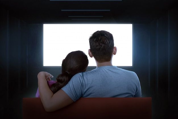 a man and woman sitting in front of a window looking at the light coming through