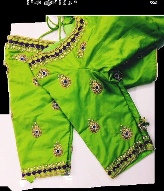 Pattu silk Light green Maggam Blouse with embroidery and kundan work on sleeves and neck. Note - Doris and Latkans provided are complementary so please do not complain about them. We do our best to put best latkans for you. Disclaimer - Actual colors may vary slightly due to computer monitors displaying settings. We try hard to match exact color. For sizes 42+ we charge extra $20 for fabric and workmanship. Please contact us before placing order, we will send you link to pay extra $20. Light Green Aari Work Blouse Design, Light Green Aari Work Blouse, Green Embroidered Saree With Mirror Work, Green Raw Silk Blouse For Navratri, Green Anarkali Blouse In Dola Silk, Green Anarkali Dola Silk Blouse, Green Blouse With Resham Embroidery For Navratri, Designer Green Blouse Piece With Mirror Work, Green Dola Silk Blouse With Cutdana