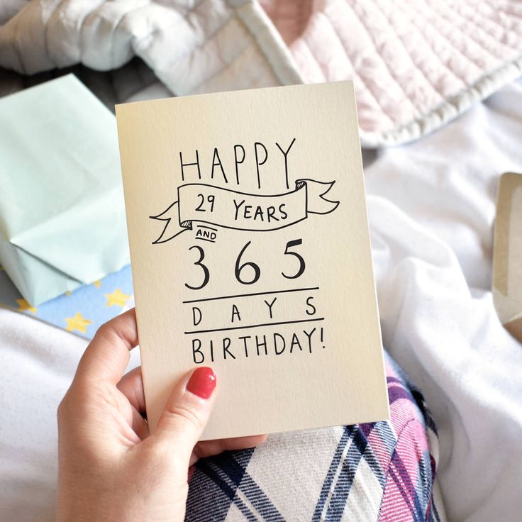 a woman holding up a birthday card with the words happy twenty years and 365 days written on it