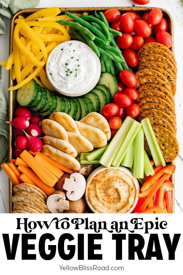 a tray filled with veggies, crackers and dip