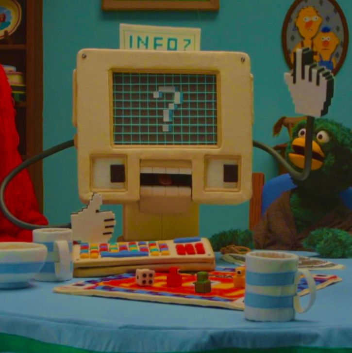 an old computer monitor sitting on top of a table next to cups and saucers