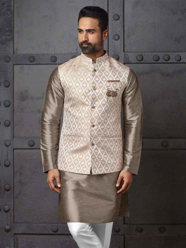 A cream-colored jacquard Nehru jacket paired with a golden brown silk kurta pajama makes a refined and stylish choice for a variety of occasions. This combination exudes sophistication while maintaining a traditional touch, making it suitable for family gatherings, weddings, festivals, and other celebrations. The rich texture of the jacquard jacket complements the luxurious silk kurta pajama, creating an elegant and cohesive look.  ndian vest,vest with kurta,eid dress,eid kurta pyjama,diwali kurta pyjama,wedding kurta COST INCLUDES NEHRU JACKET WITH KURTA PAJAMA Designer Beige Raw Silk Bandhgala, Festive Beige Nehru Jacket For Formal Occasions, Formal Cream Nehru Jacket In Raw Silk, Formal Beige Raw Silk Kurta, Designer Beige Nehru Jacket With Long Sleeves, Beige Raw Silk Kurta For Eid, Beige Nehru Jacket For Designer Wear, Festive Beige Nehru Jacket With Long Sleeves, Festive Beige Long Sleeve Nehru Jacket