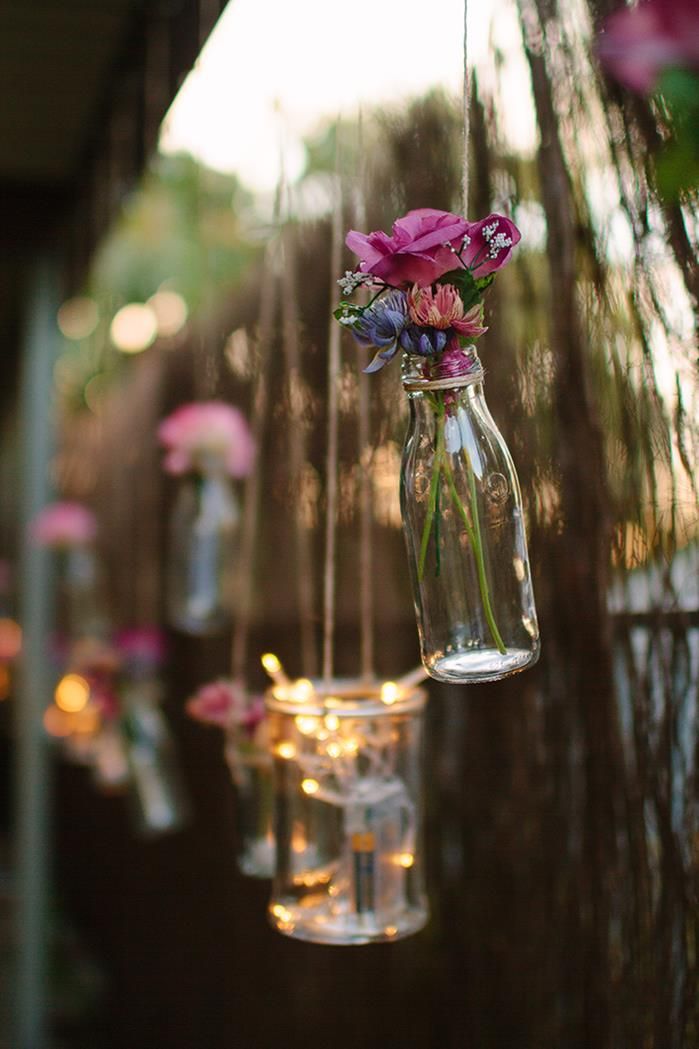 hanging glass jars filled with pink flowers