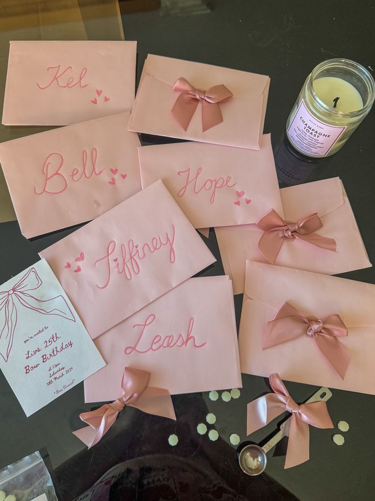 pink cards with bows and writing on them are next to a jar of teas