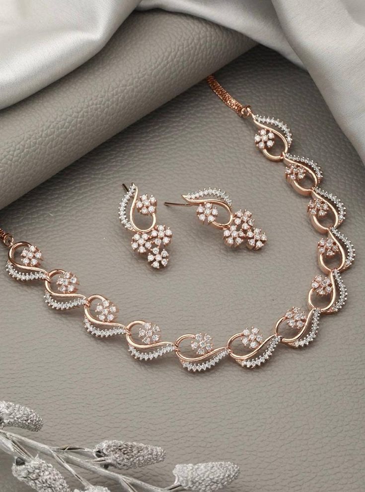 * CZ zirconia necklace and a pair of earrings * Rose gold-plated American diamond studded necklace, has a hook closure * A pair of matching drop earrings, secured with post and back closure *Size:- Length of necklace: 20 cm Length of earrings: 4 cm *Material:- Material: Brass Plating: Gold-Plated Stone Type: CZ, Zircon American Diamonds NOTE All the raw material used in this product is of high quality and is handcrafted with love. Premium Quality and High craftsmanship 100% Satisfaction Guarante Rose Gold Jewelry Set, Gold Necklace Wedding, Fancy Jewelry Necklace, Gold Jewelry Sets, Indian Necklace, Bollywood Jewelry, Diamond Jewelry Designs, Indian Wedding Jewelry, Stud Jewelry