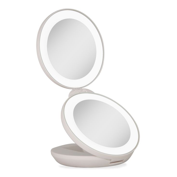 a white round mirror sitting on top of a table