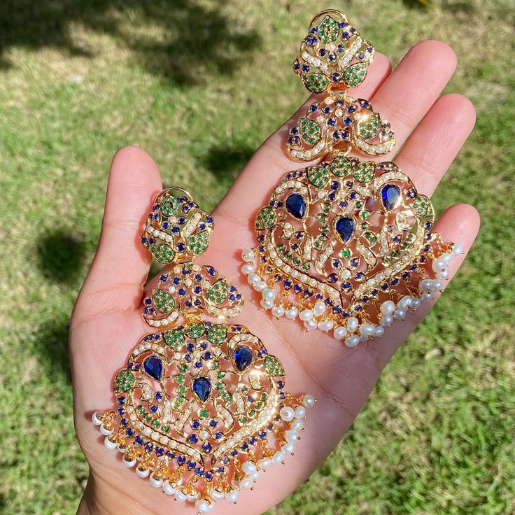 Indulge in the opulence of the Mughal era with these exquisite jadau earrings. Handcrafted using the finest 925 sterling silver, they are adorned with lustrous pearls and vibrant emeralds and sapphires, elevating your style with a touch of regal elegance. Immerse yourself in the luxury and prestige of these timeless treasures. Temple Jewelry Bridal Earrings For Eid Celebration, Elegant Pearl Meenakari Earrings For Diwali, Festive Heavy Temple Jewelry Earrings, Temple Jewelry Bridal Earrings For Eid, Temple Jewelry Bridal Earrings For Festive Eid, Elegant Meenakari Chandbalis For Diwali, Fusion Style Jewelry With Meenakari For Eid, Fusion Style Meenakari Jewelry For Eid, Elegant Meenakari Pearl Earrings For Festivals