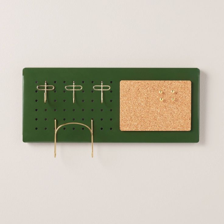 a green board with three pegs and two pairs of glasses hanging from it's hooks