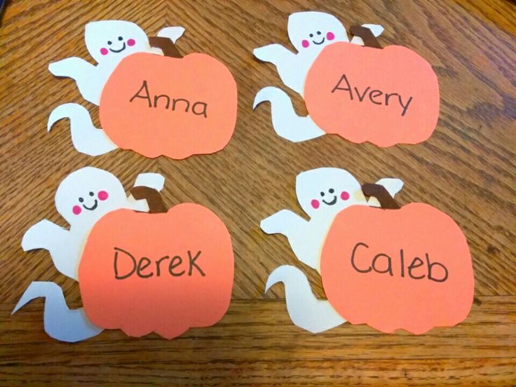 four pieces of paper cut out to look like halloween pumpkins with names on them