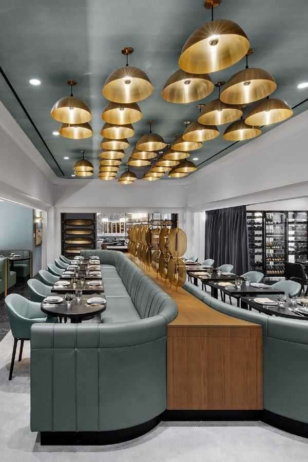 the restaurant is decorated in modern style with gold fixtures and blue upholstered seating