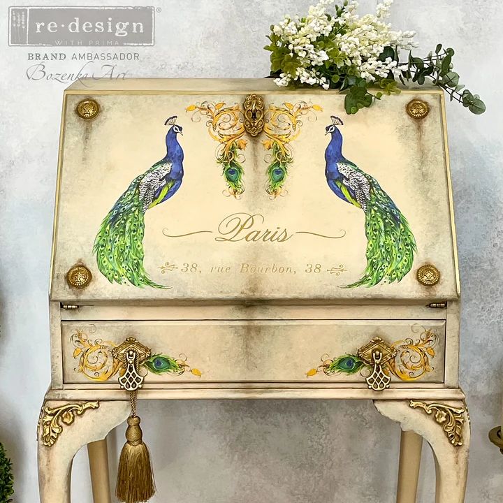 an ornate painted piano with two peacocks on the front and side, sitting next to flowers