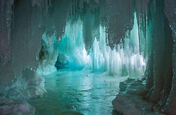 an ice cave filled with water and icicles