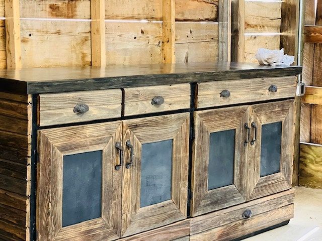 an old wooden cabinet with chalkboard on the top and bottom, in a shop