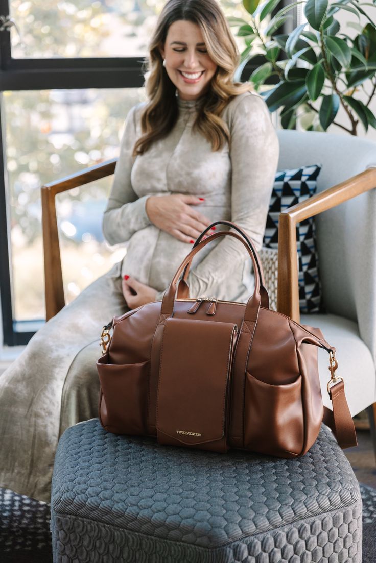 Equal parts stylish and spacious, our vegan leather Peek-A-Boo Diaper Bag Satchel is made for moms who do it all—just like the bag itself. And don't be fooled by this beauty. While the satchel diaper bag is purposely designed to look and feel more like a fashion bag, it has all the features and functions of a true diaper bag hidden inside, including plenty of pockets. You can carry the Satchel with the vegan leather top handle or wear it as a crossbody via the padded long strap. Brown Diaper Shoulder Bag, Brown Diaper Bag For Everyday Use, Brown Diaper Bag With Double Handle For Daily Use, Versatile Brown Diaper Bag For On-the-go, Leather Diaper Bag With Large Capacity For Everyday Use, Versatile Leather Satchel Diaper Bag, Brown Diaper Bag With Adjustable Strap, Everyday Brown Diaper Bag With Adjustable Strap, Leather Diaper Bag With Detachable Strap