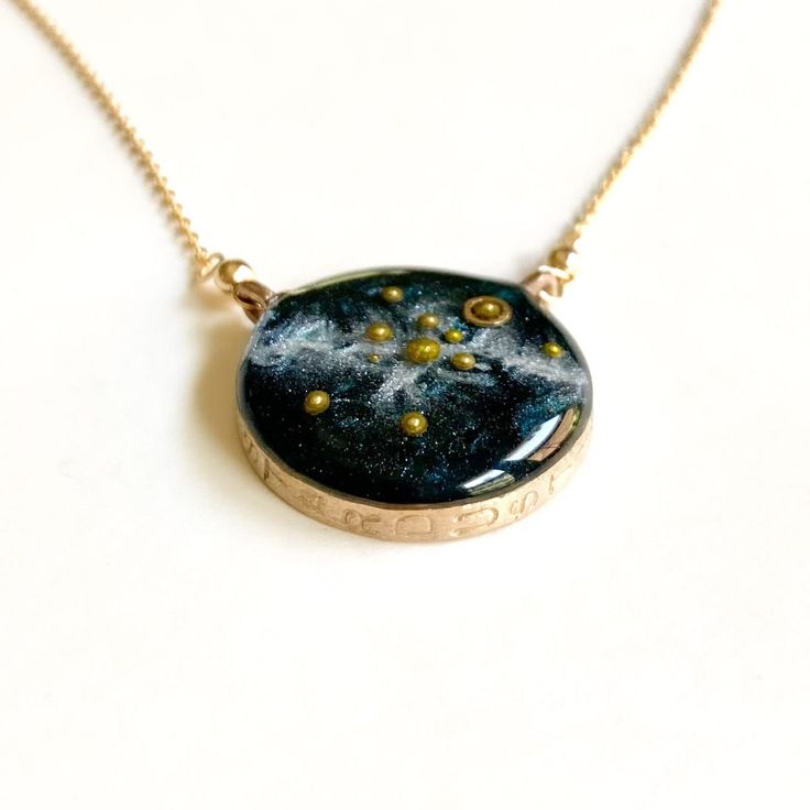 "A beautiful, handmade reminder of our place in the universe and connection to each other.  This Solar System Necklace has golden glass microbeads carefully hand placed to create our sun and planets on a backdrop of the shimmering milky way galaxy made of mica. The scene floats in a sparkling inky resin and is covered with a clear dome, adding dimensions and depth to this celestial scene.  Stamped with the word STARDUST, the bezel is hand cast from your choice of sterling silver or bronze and ha Space-themed Gold Jewelry Gift, Handmade Celestial Necklaces, Handmade Cosmic Jewelry For Gifts, Handmade Cosmic Style Jewelry For Gifts, Cosmic Style Handmade Jewelry As A Gift, Celestial Round Pendant For Healing, Celestial Round Pendant Jewelry For Healing, Celestial Satellite Chain Jewelry As Gift, Celestial Jewelry With Satellite Chain For Gifts