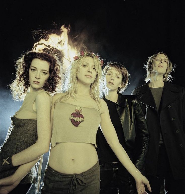 a group of young women standing next to each other in front of a black background