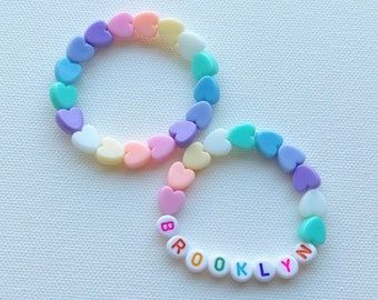 two bracelets with words and hearts on them, one saying brooklyn the other says brooklyn