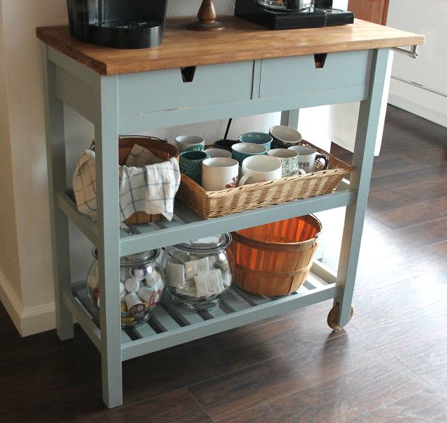 a kitchen island with coffee maker on top and baskets under the countertop in front of it