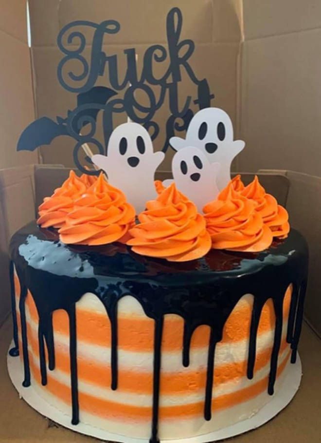 a halloween cake with orange frosting and ghost decorations