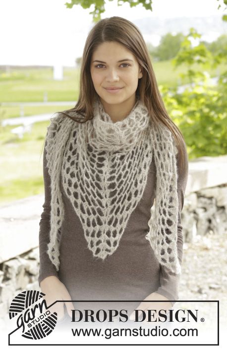 a woman standing in front of a tree wearing a white shawl with crochet