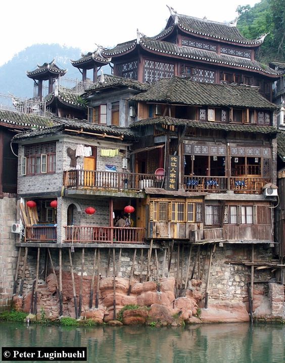 an old building with lots of balconies on the roof and balconys above water