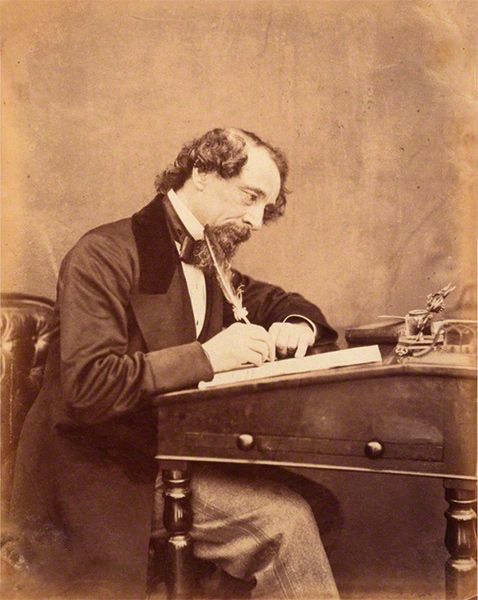 an old photo of a man sitting at a desk writing